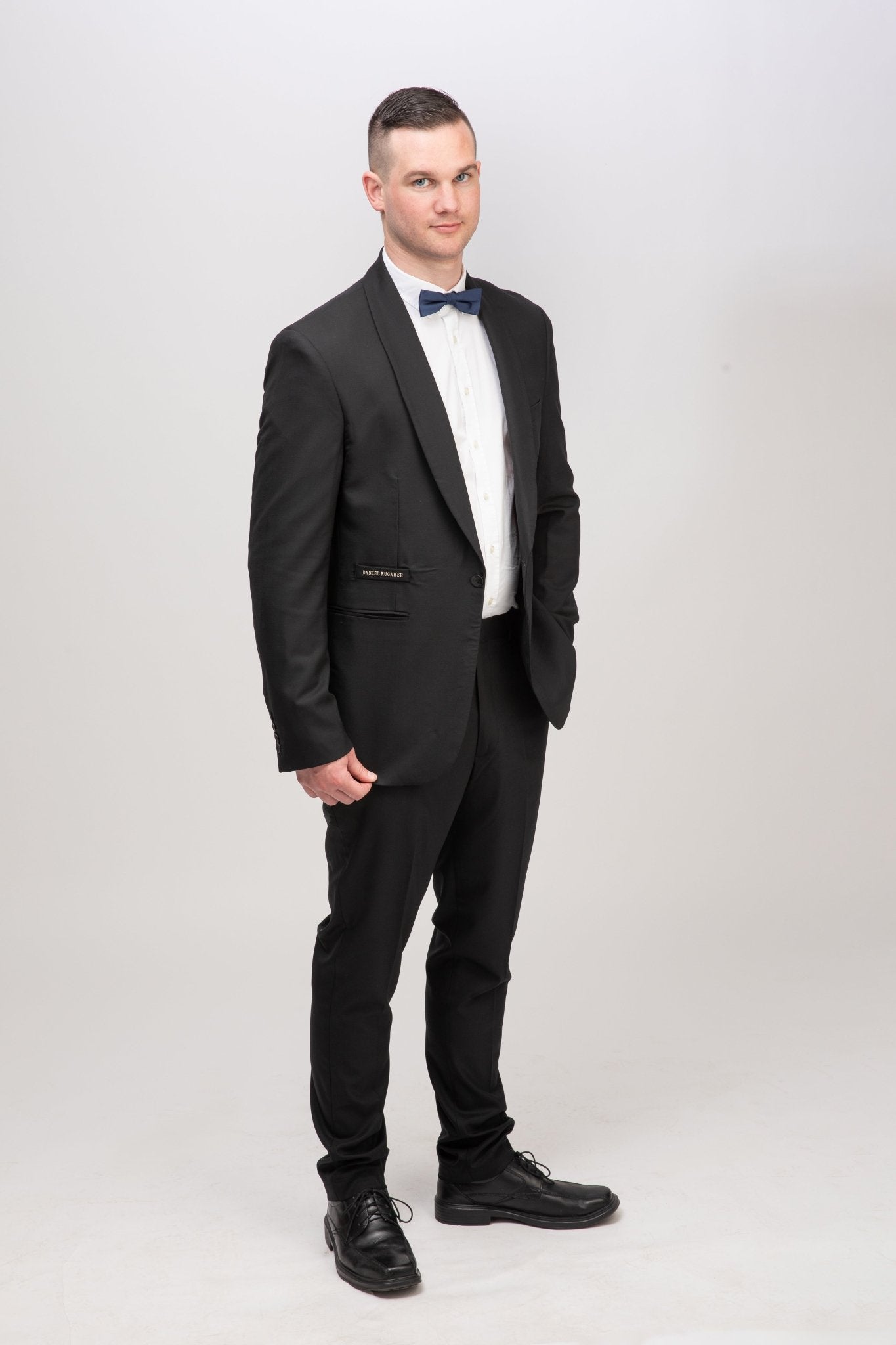 Tiefschwarzer Rundhals Anzug - elegante Frontansicht, modern konturiert mit Smoking Schalkragen.