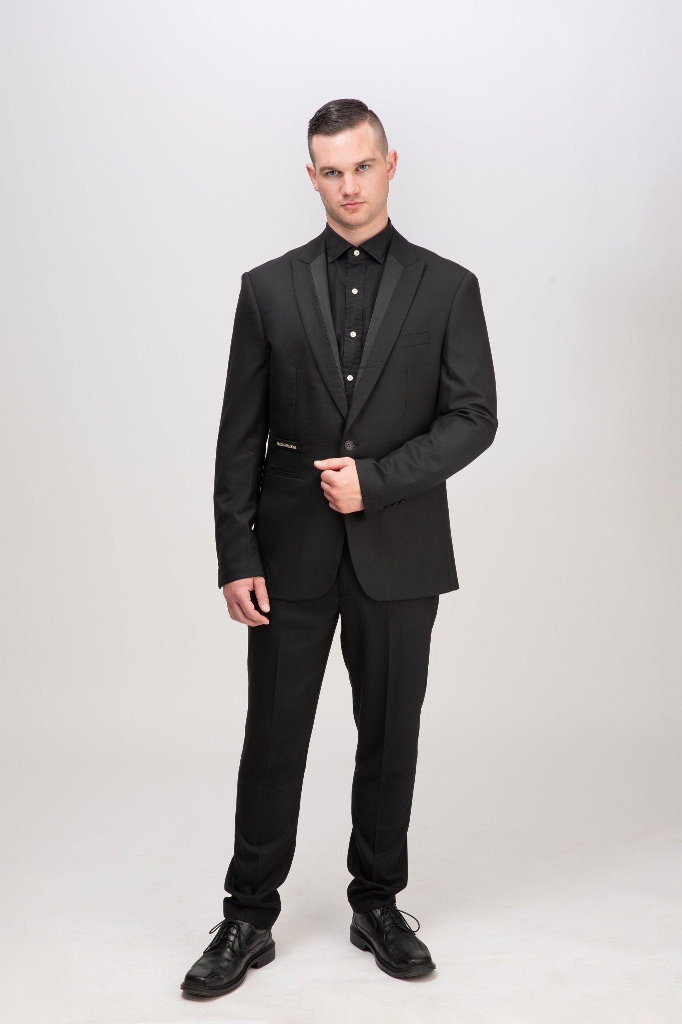 Eleganter schwarzer Signature Anzug mit markantem Spitzkragen - perfekt inszeniert, Ausdruck maskuliner Autorität und zeitloser italienischer Schneiderkunst.