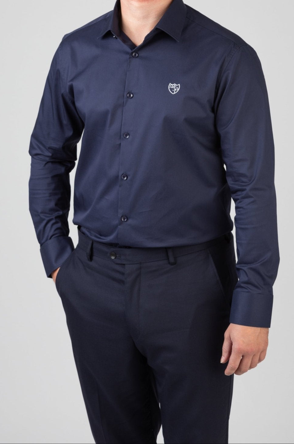 Marineblaues Signature Hemd aus edler Baumwolle mit fein gesticktem weißem Wappenlogo - Ausdruck stilvoller Souveränität und italienischer Handwerkskunst.