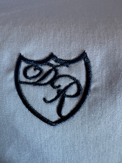 Handgefertigte Wappenstickerei in leuchtendem Königsblau - Symbol für höchste Exklusivität.