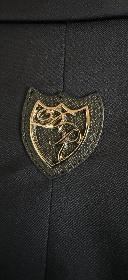 Ikonisches Metalllogo Daniel Rügamer auf der Passe - edles Designelement für den sportlich-eleganten Signature Anzug.