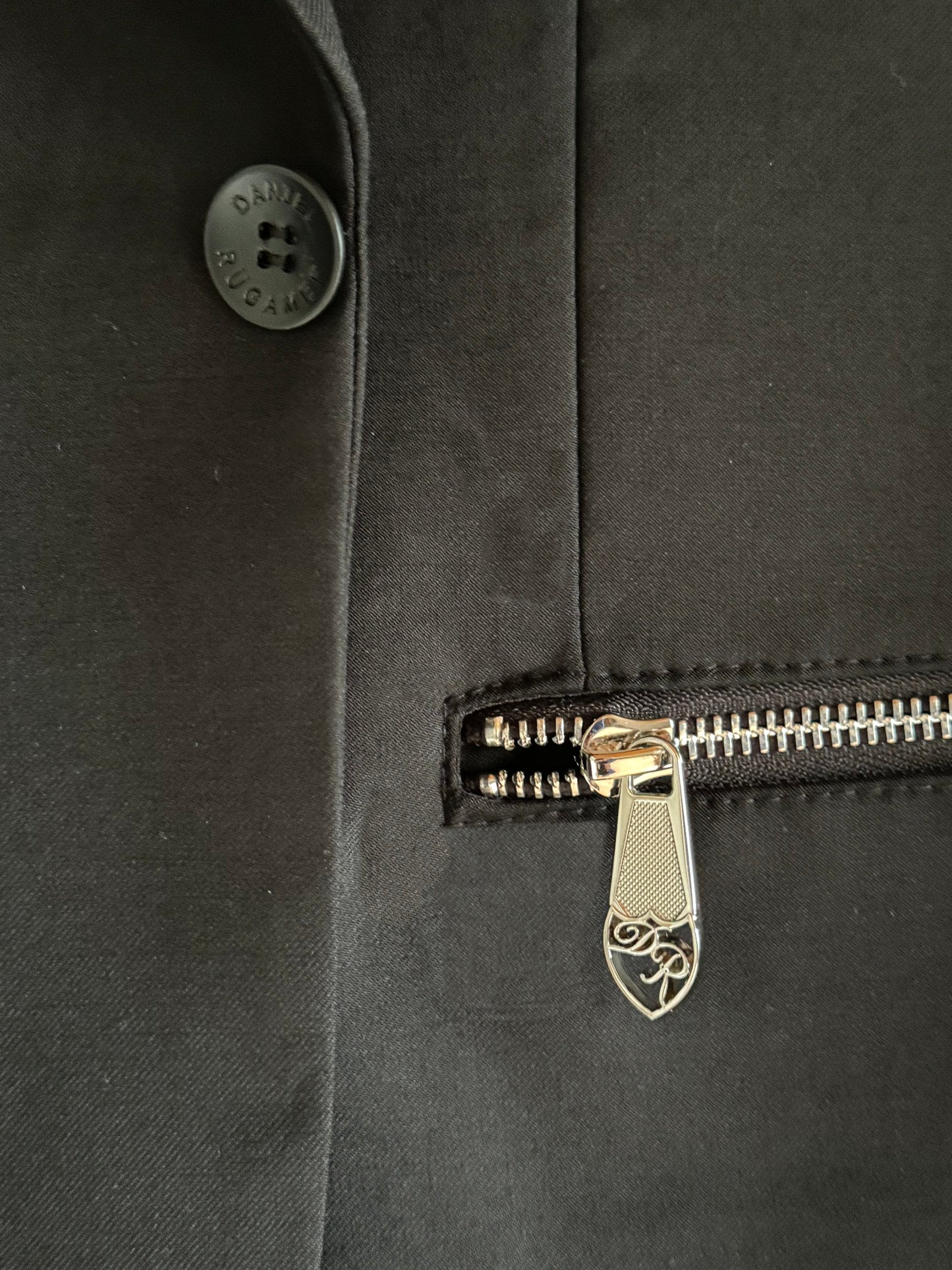 Feines Reißverschlussdetail am sportlichen Signature Anzug - innovative Designnote, die Komfort und Luxus vereint.