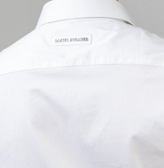 Rückansicht des weißen Signature Hemds - dezenter Metallname auf der Passe, Symbol handwerklicher Perfektion und zeitloser Eleganz.